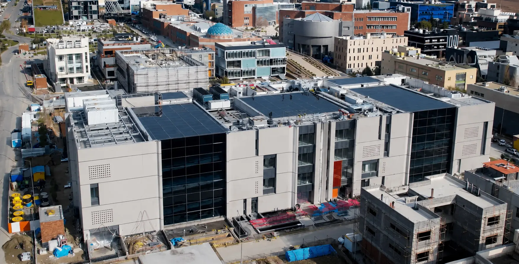 The Fanap building from the air within the surrounding city fabric, a glazed courtyard end between the clad blocks