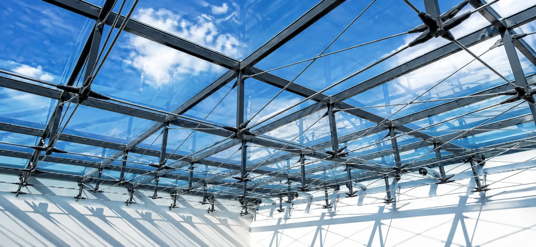 The Fanap cable truss skylight from below — slim steel held against tie rods in tension, the sky visible through the grid