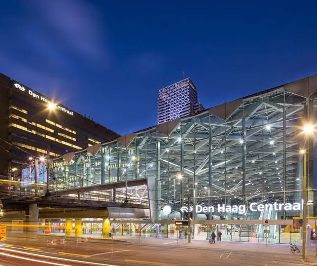 Reference example: a shallow barrel vault glass roof over a station concourse at dusk