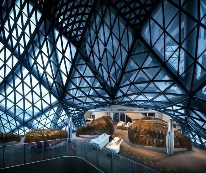 Reference image: a steel lattice shell with triangulated glazing over an interior