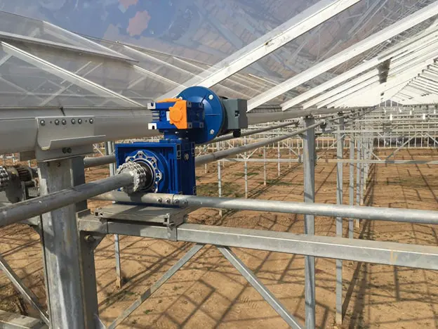 Rack-and-pinion gear motor mounted on the vent drive shaft beneath a Venlo greenhouse roof