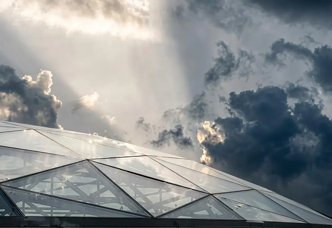 The Yas skylight from below, faceted glazing against a breaking sky